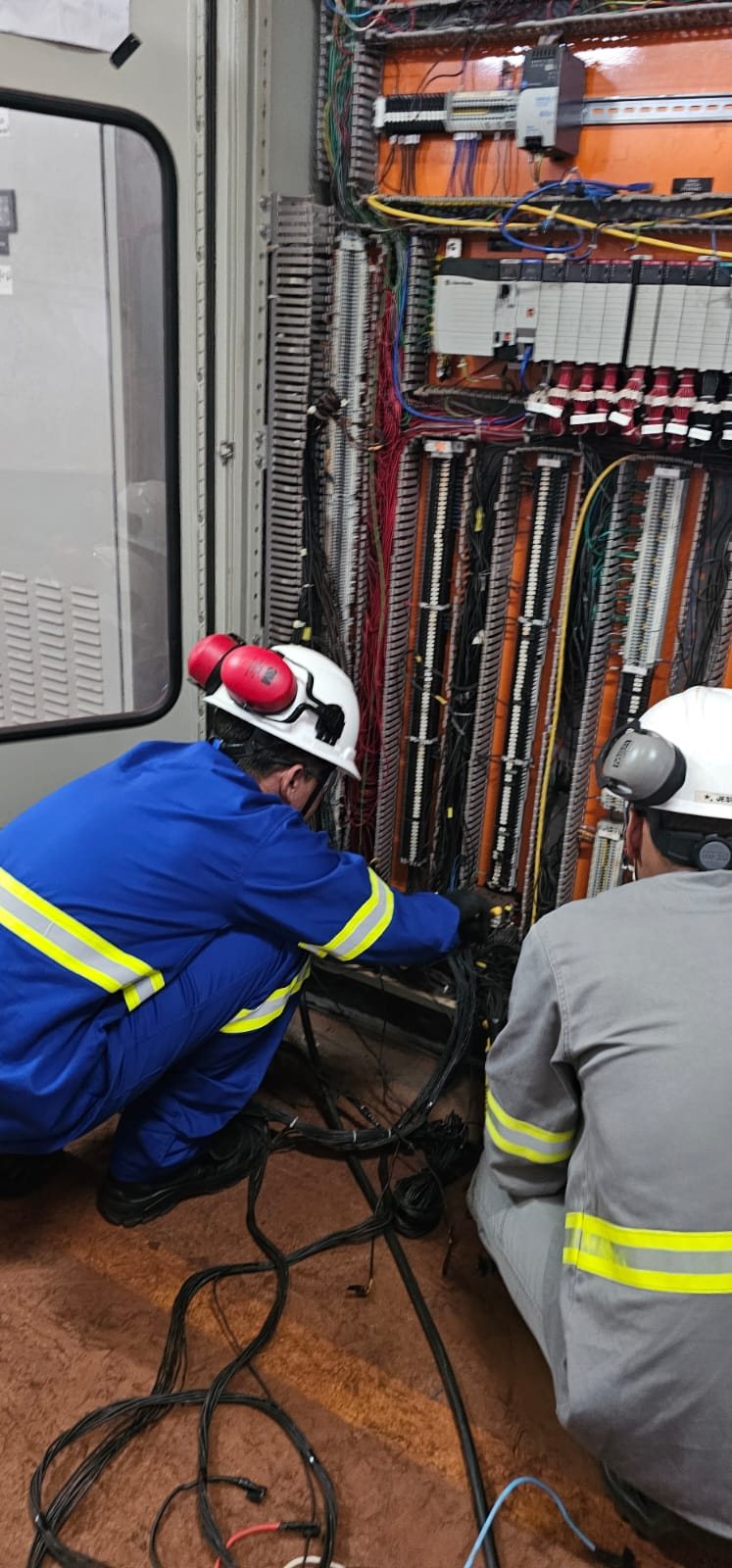 VLI — retrofit de painéis de PLC no TPSL 6 Equipe trabalhando no interior do painel de automação